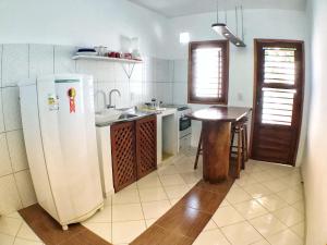 a kitchen with a refrigerator and a table in it at Villa Guarani Jeri in Jericoacoara