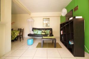 a living room with a couch and a table at Appartement Vacances Goyave in Cap Chevalier +10 photos