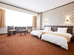 a hotel room with two beds and a large window at International Bucharest City Centre Hotel in Bucharest