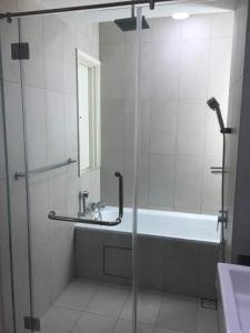 a bathroom with a shower and a tub and a sink at Afiniti Muslim Medini Condo in Nusajaya