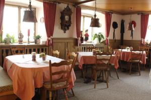a dining room with two tables and a clock on the wall at Adler Post in Lenzkirch