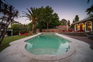 a swimming pool with a pool table and chairs at Boutique Villa Guesthouse in Somerset West