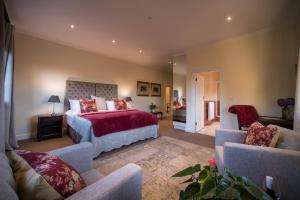 a bedroom with a large bed and a living room at Boutique Villa Guesthouse in Somerset West
