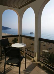 d'une table et d'une chaise sur un balcon avec vue sur l'océan. dans l'établissement Apartaments Rosanna, à Lloret de Mar