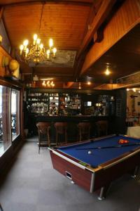 a pool table in a room with a bar at Hotel La Chaumiere in Saint-Gervais-les-Bains