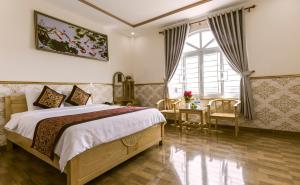 um quarto com uma cama grande e uma janela em AEC Hotel Ban Me em Buon Ma Thuot