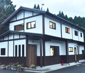 a white house with a lot of windows at Wakka in Minami Aso