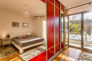 a bedroom with a bed and a large window at Nina in Herceg-Novi