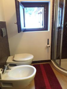リモーネ・ピエモンテにあるCasa del Principeのバスルーム(トイレ、洗面台付)、窓が備わります。