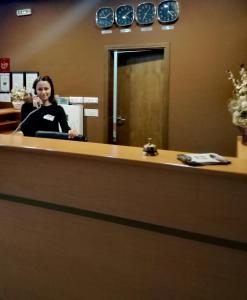 a woman sitting at a reception desk in an office at Hotel Mizia in Targovishte