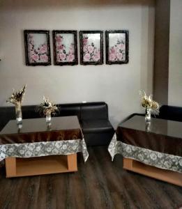 dos mesas en una habitación con tres cuadros en la pared en Hotel Mizia en Targovishte