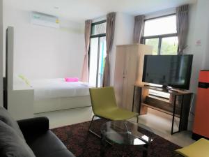a living room with a couch and a television at Baan der Bruyn in Jomtien Beach