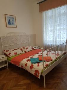 a bedroom with a bed with a red and white comforter at Valentina Guesthouse in Budapest
