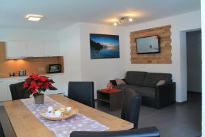 ein Wohnzimmer mit einem Tisch und einem Sofa in der Unterkunft Apart Alpinlive in Ladis