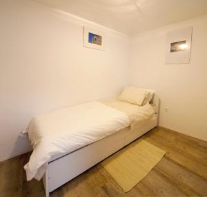 a small bed in a room with white walls at Apartment Alex in Piran