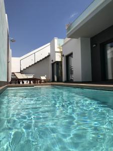 a swimming pool in front of a house at Casa La Nao in Playas de Orihuela