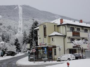 un edificio en una calle con nieve en el suelo en Garni Hotel Terano, en Maribor