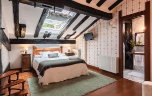 a bedroom with a large bed and a skylight at Casa Rural Jesuskoa in Zumaia