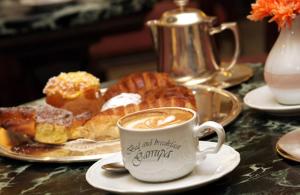 una mesa con una taza de café y un plato de repostería en Bed & Breakfast Garrupa, en Marcellinara