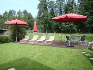 eine Terrasse mit Stühlen, Tischen und Sonnenschirmen in der Unterkunft Bella Casa in Langenargen