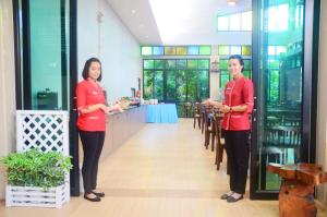 zwei Frauen in roten Hemden stehen in einem Restaurant in der Unterkunft Andaman Pearl Resort in Ao Nang Beach