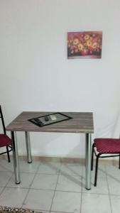 a wooden table with a picture on the wall at Apartments Petrovic in Krimovice