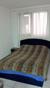 a bed in a bedroom with a leopard print bedspread at Apartments Petrovic in Krimovice