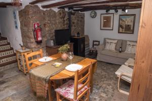 Una sala de estar con una mesa de madera y un sofá. en L'Arc de Pedra, en Vilafamés