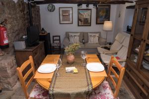 Una sala de estar con una mesa y sillas de madera. en L'Arc de Pedra, en Vilafamés