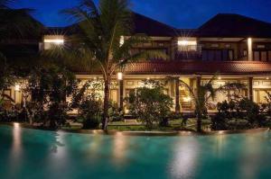 uma casa com piscina em frente a um edifício em Bucu Guest House em Ubud