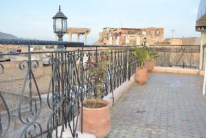 a wrought iron fence with potted plants and a street light at dar hassbia in Fez