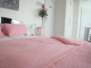 ランゲナルゲンにあるBella Casaのピンクの掛け布団付きのピンクベッドが備わるベッドルーム1室が備わります。