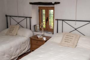a bedroom with two beds and a wooden table at L'Arc de Pedra in Vilafamés