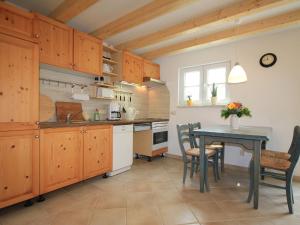 a kitchen with wooden cabinets and a table with chairs at Modern Holiday Home in Steffenshagen with Terrace in Steffenshagen