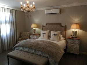 - une chambre avec un lit, deux lampes et un lustre dans l'établissement Mountain View Country Guest House, à Cradock