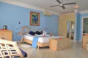 a bedroom with a bed with blue walls at Villa De Cerf in Cerf Island