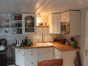 a kitchen with white cabinets and a sink at Quaint Holiday Home in Schwaan near the Lake in Schwaan