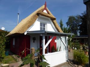 a small cottage with a thatched roof at Quaint Holiday Home in Schwaan near the Lake in Schwaan