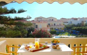 a table with a plate of fruit on a balcony at Raisakis Apartments in Agia Marina Nea Kydonias