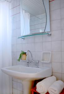 a bathroom with a sink and a mirror and towels at Raisakis Apartments in Agia Marina Nea Kydonias