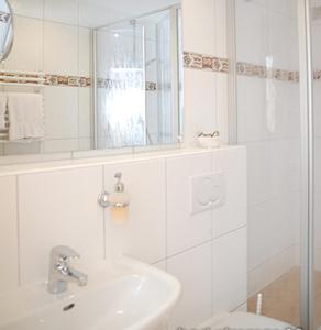 a white bathroom with a sink and a mirror at Aqua Marina in Helgoland