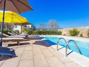 una piscina con sombrillas y sillas y una piscina en Belvilla by OYO Villa 13, en Consell