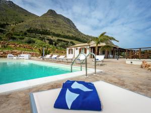 a resort with a swimming pool and mountains in the background at Belvilla by OYO Mari e Monti 4 in Castellammare del Golfo