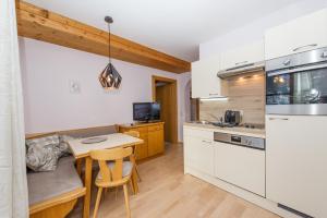 a kitchen with white cabinets and a table and a counter at Haus Fercher in Grossarl