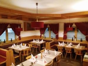 a restaurant with white tables and chairs and windows at Gasthof Falter in Straubing