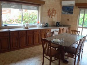 a kitchen with a table and a table and chairs at House near Fontelo in Viseu