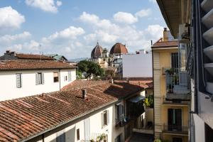 a white building with a white roof and a blue sky at Hotel Fiorita in Florence