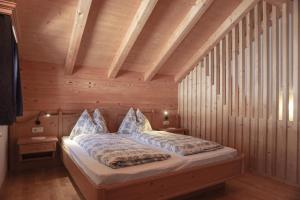 a bedroom with a bed in a wooden room at Apartments Ciastel in San Vigilio Di Marebbe