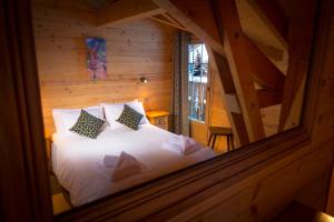 a bedroom with a white bed in a wooden cabin at Simply Morzine - Chalet Carving in Morzine