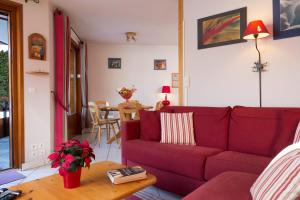 モルジヌにあるSimply Morzine - Apartment le Sautailletのリビングルーム(赤いソファ、テーブル付)